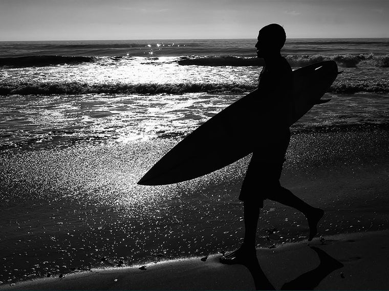Surfer walking out at low tide