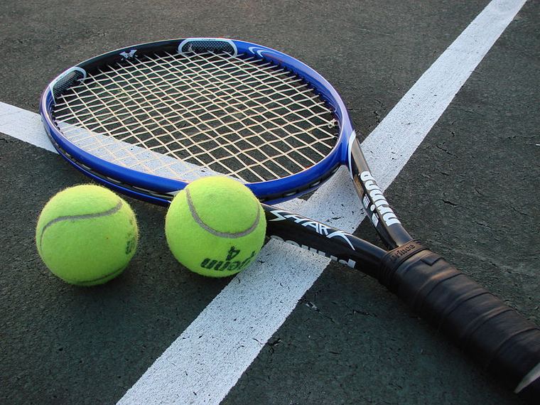 Racket and balls resting on the baseline